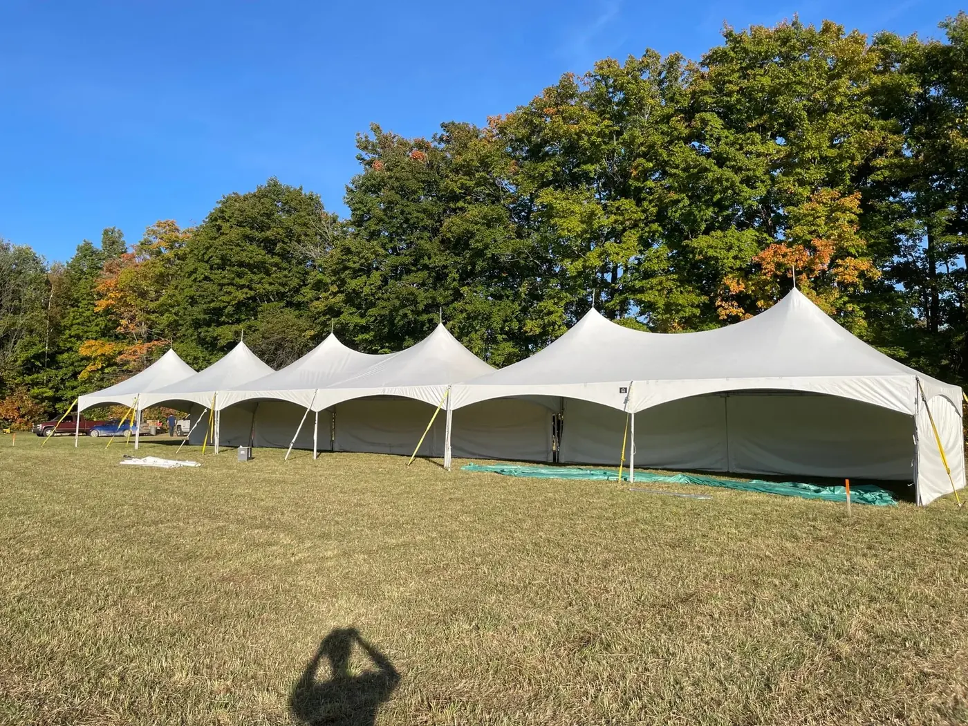 Long white event tent with open sides and space for an outdoor gathering