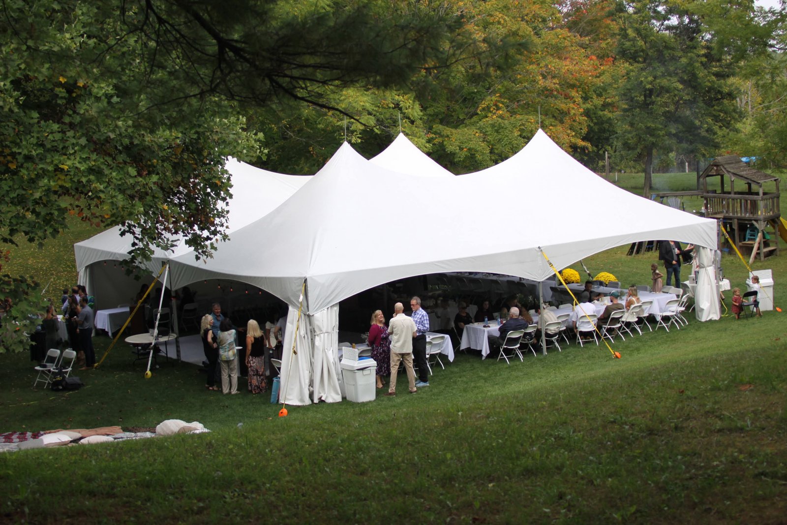 White tent with dining tables arranged for a wedding